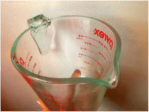Measuring cup, or anything with a good lip for pouring